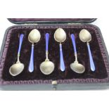 A set of six silver gilt and blue enamel coffee spoons, in vendors leather case