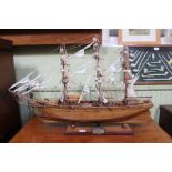 A well made wooden scale model of The Cutty Sark, mounted on a plinth base