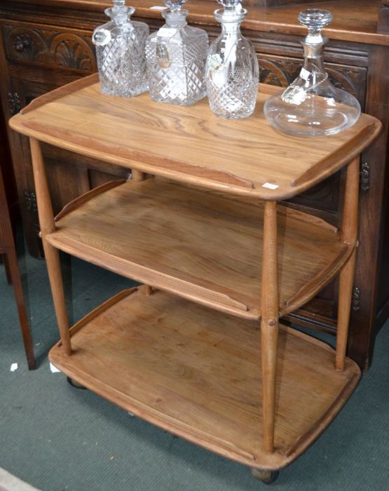 An Ercol three tier tea trolley on original casters, remnants of the original label