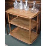 An Ercol three tier tea trolley on original casters, remnants of the original label