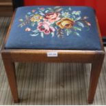 A 19th century mahogany stool with floral wool work pad top