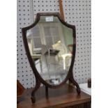 An early 19th century mahogany framed shield dressing table mirror with folding stand