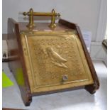 An oak and brass coal box, the hinged cover with an embossed brass panel depicting an owl, fitted br