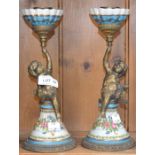 A pair of porcelain candlesticks with brass "Putti's"