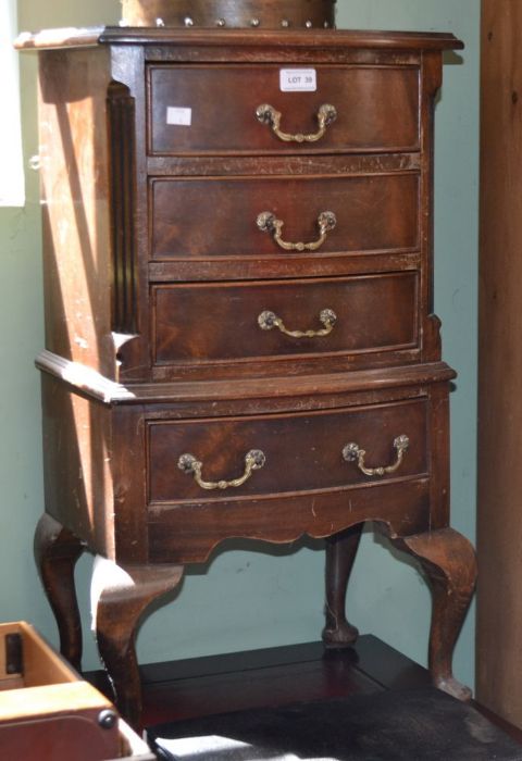 A reproduction four drawer chest on legs