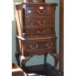 A reproduction four drawer chest on legs