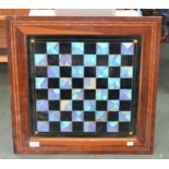 A chessboard with iridescent butterfly wing and black glass squares