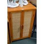 A pine and wicker storage cupboard