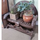A novelty painted wooden two person bench formed from a vintage cart wheel