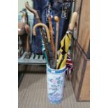 Oriental design ceramic cylindrical stick stand containing s election of sticks and brollies