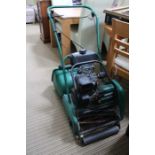 A Qualcast Classic petrol driven cylinder lawn mower with grass collection box