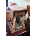 A good quality turned oak coffee table with oval twin-flap rotating top