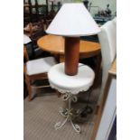 A painted metal circular topped table with a leather covered table lamp with shade