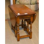 A small oak twin-flap coffee table on baluster turned gate-leg action by "Old Charm"