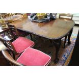 An early 20th century mahogany wind out dining table, with carved ropework edge on four carved cabri