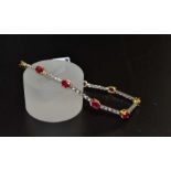 An 18ct gold bracelet comprising nine oval Rubies set in yellow gold having four claw settings, havi