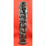 A 20th century carved ebony column of embedded figures, 60cm high