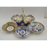 A late 19th century floral encrusted porcelain bon-bon basket, and three porcelain saucers