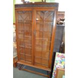 Oak free standing bookcase with twin glazes doors and adjustable shelved interior