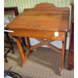 A mid-20th century oak child's slope top desk, back set pen trays, hinged lid opens to reveal storag