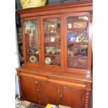 A Victorian mahogany bookcase the glazed upper section on a cupboard base