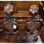 A pair of Arts & Crafts design wrought iron fire dogs with copper embossed decoration including flor