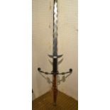 A large two handed wavy edged blade re-enactment sword with large metal guard