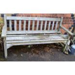 A teak slatted garden bench of typical form