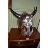 A metal combat re-enactment helmet with twin black horns