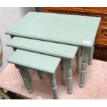 A green painted nest of three pine tables