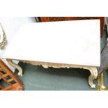 A marble topped heavily carved white painted coffee table