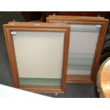 A pair of wall hanging glass fronted display cabinets
