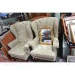 A pair of green and cream upholstered wingback armchairs