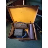 Small tan suitcase containing other bags and purses