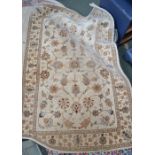A cream ground woven rug with floral patterns
