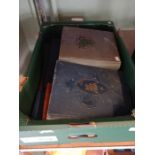A box containing vintage postcard albums