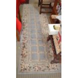 A Chinese washed wool runner of trellis design with floral border 76 x 342 cm