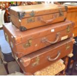 Three vintage tan suitcases - retaining some travel labels