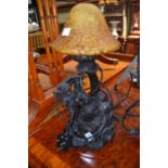 A reproduction figural table lamp in the form of two fairies beneath a large mushroom