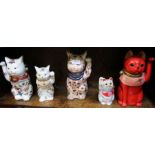 A collection of five pottery Japanese 'Maneki Neko' good luck cats