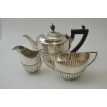 Sibray Hall & Co. A silver bachelor tea set , comprising: teapot, sugar bowl and milk jug, of fluted