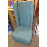 A turquoise upholstered high back chair