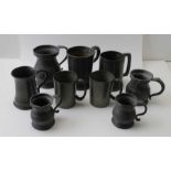 A collection of various sized pewter mugs