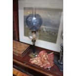 A 19th century oil lamp with blue shade and a painted plaster cherub wall light