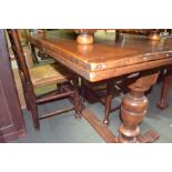 A reproduction oak finished draw-leaf table on turned baluster columns on an H shaped stretcher