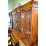 A well made quality reproduction Yew wood break front bookcase fitted with a slide