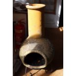 A well weathered terracotta garden chimenea