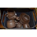A basket of 1970's brown glazed stoneware breakfast set