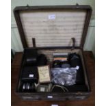 A leather case containing a selection of camera lenses, exposure meters and other similar