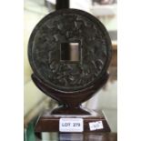 A Chinese large bronze cash coin, cast decoration, 13cm dia, with wooden stand